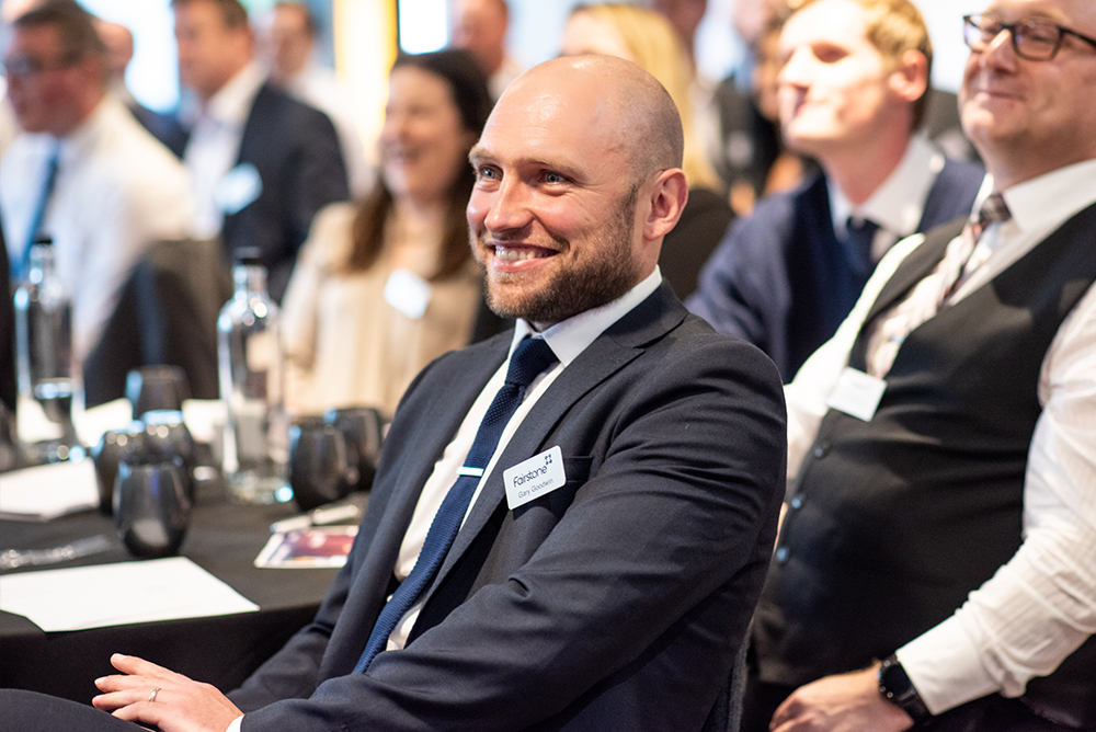Culture-Thumbnail Fairstone employee sits and smiles whilst attending Fairstone annual conference