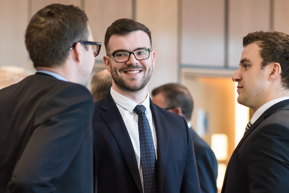 Join-the-team-Thumbnail Three Fairstone staff face each other wearing suits whilst having a conversation
